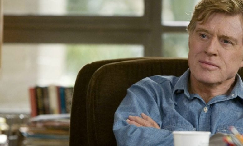 Robert Redford sitting at a table