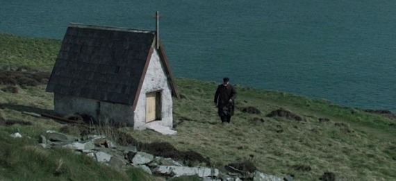 A person standing in front of a house, with Gerard Butler