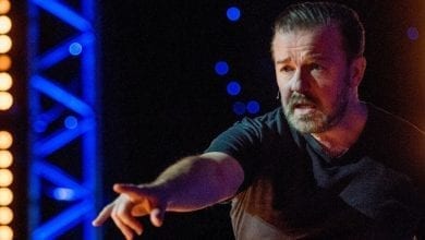 Ricky Gervais standing on a stage